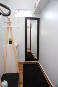 a hallway with a mirror and a black rug at Edícula Próxima a Praias! in São Luís
