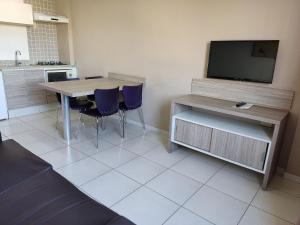 a kitchen with a table with chairs and a tv at Riviera Park in Caldas Novas