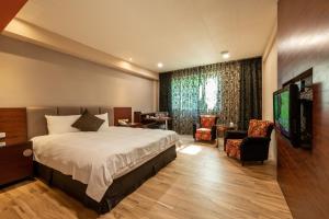 ein Hotelzimmer mit einem Bett und einem Flachbild-TV in der Unterkunft Chia Shih Pao Hotel in Taibao
