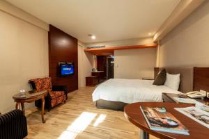 um quarto de hotel com uma cama e uma secretária em Chia Shih Pao Hotel em Taibao