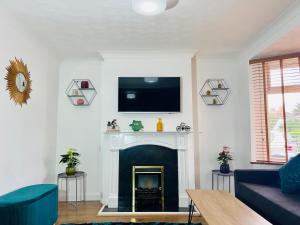 a living room with a fireplace with a tv above it at Beautiful 3 bedroom house with garden + Parking in Oxford