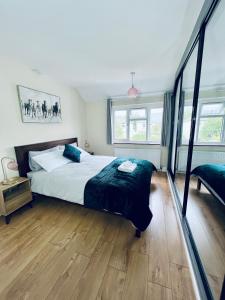 a bedroom with a large bed and wooden floors at Beautiful 3 bedroom house with garden + Parking in Oxford