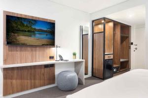 a bedroom with a desk and a tv on a wall at Killara Hotel & Suites in Killara