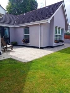 a house with a patio and a lawn at Mary's place in Castlewellan