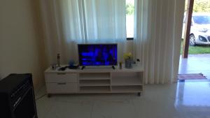 un televisor sentado en un tocador en una sala de estar en Casa condominio Rancho de Jacone, en Maricá