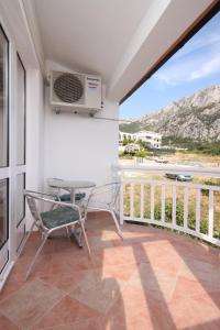 a room with a balcony with a table and a heater at Apartments with a parking space Gradac, Makarska - 6820 in Gradac