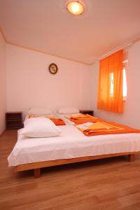 una camera da letto con un letto con lenzuola bianche e una finestra di Apartments with parking space Gradac, Makarska - 6820 a Gradac (Grado)