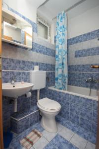 un bagno piastrellato blu con un water e un lavandino di Apartments with parking space Gradac, Makarska - 6820 a Gradac (Grado) Altre 36 foto