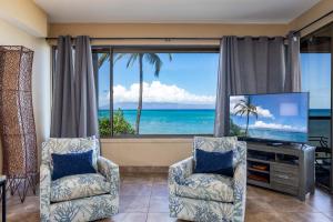 a living room with two chairs and a flat screen tv at Sands Of Kahana 315 2Bd 2Ba Oceanfront condo in Kahana