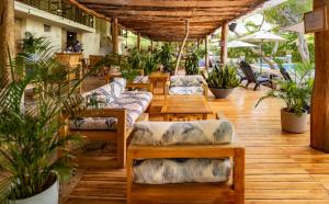 een patio met banken, tafels en potplanten bij Blue Apple Beach in Tierra Bomba