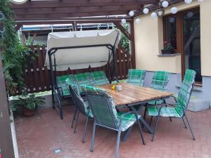 een tafel en stoelen onder een parasol op een patio bij Modern holiday home on the outskirts of Saxon Switzerland with covered terrace in Hohnstein