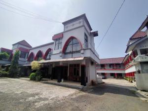 a large white building with a balcony on it at Hotel Asri Baru in Purwokerto