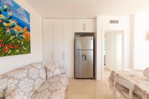 uma sala de estar com um sofá e um frigorífico em Curri Case al Mare em Monopoli