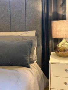 a bed with a pillow and a lamp on a nightstand at Modern Deluxe Apartment London Camberwell Denmark in London