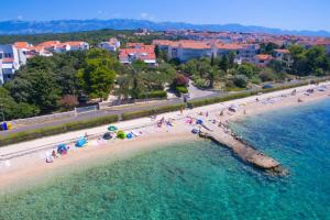 an aerial view of a beach with people in the water at Holiday house with a parking space Novalja, Pag - 6492 in Novalja