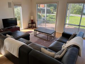 a living room with a couch and a table at Kangaroo Pause Holiday home at Clayton Bay in Clayton Bay