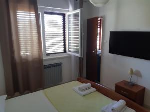 a bedroom with a bed and a tv and windows at Double Room Jakisnica 4160d in Lun