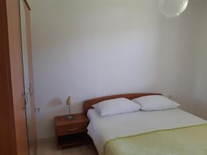 a bed with two white pillows and a night stand at Double Room Jakisnica 4160d in Lun