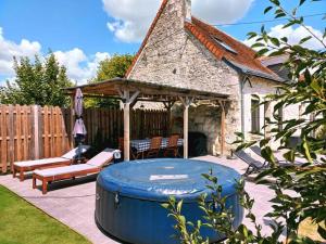 Beautiful villa in central France في La Chapelle-Blanche-Saint-Martin: حديقة خلفية مع شرفة وحوض استحمام ساخن