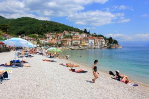 a group of people on a beach in the water at Rooms by the sea Moscenicka Draga, Opatija - 7767 in Mošćenička Draga