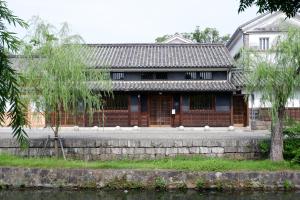 un edificio accanto a un corpo idrico di 滔々 倉敷民藝館南の宿 toutou, Mingeikan Minami no Yado a Kurashiki