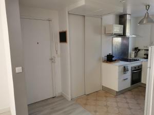 małą kuchnię z białymi szafkami i kuchenką w obiekcie Superbe appartement Montpellier 8 personnes 2 chambres 2 salles de bain Wifi Netflix et parking gratuit w Montpellier +11 zdjęć