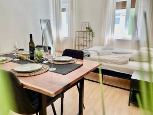 een eettafel met borden en wijnglazen bij Central Comfy Apartment - Self Check-in in Graz