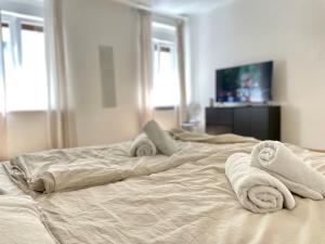 een slaapkamer met 2 bedden en handdoeken bij Central Comfy Apartment - Self Check-in in Graz