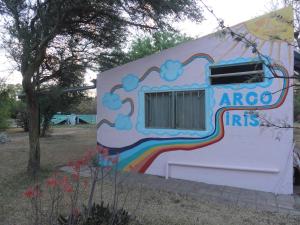 una casa con un arco iris pintado a un lado de ella en Posada Vegetariana Arco Iris en San Marcos Sierras