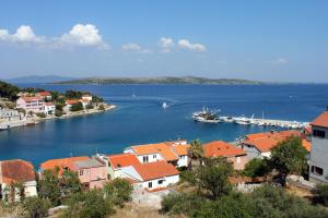 a town with a harbor and a boat in the water at Apartments with a parking space Sali, Dugi otok - 8181 in Sali