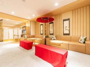 京都市にあるホテルアベストグランデ京都清水の長椅子と赤いテーブルが備わる待合室