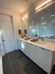 a bathroom with two sinks and a large mirror at Entire Home Close to BOA Stadium & City in Charlotte