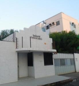 ein weiß gefliestes Gebäude mit einem Zaun davor in der Unterkunft Apartamento, Zona Leste, ótima localização. in Teresina