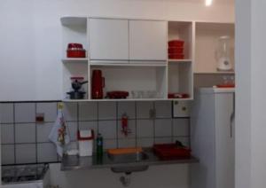 eine Küche mit weißen Schränken und einem Waschbecken in der Unterkunft Apartamento, Zona Leste, ótima localização. in Teresina