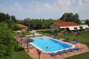 einen Blick über einen Pool mit Stühlen und Sonnenschirmen in der Unterkunft Villagio in Lefkada Town