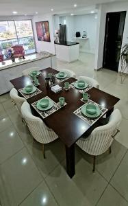 Espectacular Penthouse dúplex bien equipado في بارانكويلا: طاولة خشبية حولها كراسي في مطبخ