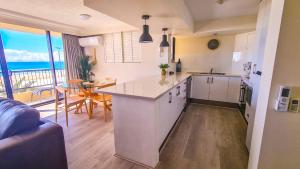 a kitchen and living room with a view of the ocean at Pelican Sands Beach Resort in Gold Coast
