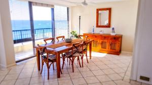 comedor con mesa y sillas y balcón en Pelican Sands Beach Resort, en Gold Coast