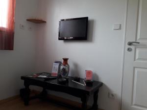 a room with a table with a tv on a wall at Chambre Is in Is-sur-Tille