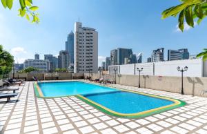 a swimming pool on the roof of a building with a city at Omnitower two bedroom cozy apartment in Bangkok