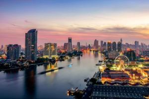 a city skyline at night with a river and buildings at Omnitower two bedroom cozy apartment in Bangkok