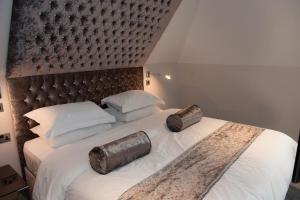 a bedroom with a large bed with a large headboard at Hotel Forty One in Great Driffield