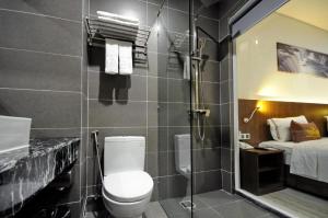 a bathroom with a toilet and a shower and a bed at Crown Nguyen Hoang Hotel in Nha Trang