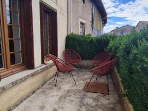 drei rote Stühle vor einem Gebäude in der Unterkunft Charme et authenticité : Gîte 6 pers, rénové, jardin, proche commerces et randonnées - FR-1-585-86 in Mauvages