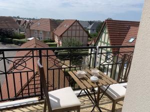 a balcony with a table and chairs on a balcony at Appartement Dives-sur-Mer, 2 pièces, 4 personnes - FR-1-487-236 in Dives-sur-Mer