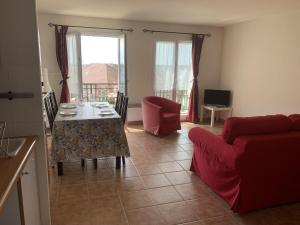 a living room with a table and a red couch at Appartement Dives-sur-Mer, 2 pièces, 4 personnes - FR-1-487-236 in Dives-sur-Mer