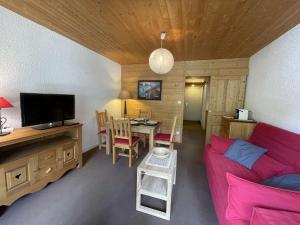 een woonkamer met een rode bank en een tafel bij Appartement Saint-Chaffrey , 1 pièce, 4 personnes - FR-1-330E-126 in Saint-Chaffrey