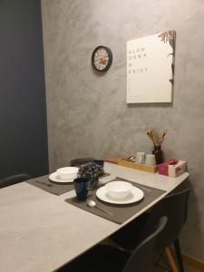 a table with two plates and a clock on the wall at Best Moments studio balcony- Imperium Resident in Kuantan