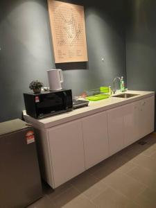 a kitchen counter with a microwave and a sink at Best Moments studio balcony- Imperium Resident in Kuantan