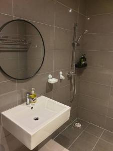a bathroom with a white sink and a mirror at Best Moments studio balcony- Imperium Resident in Kuantan